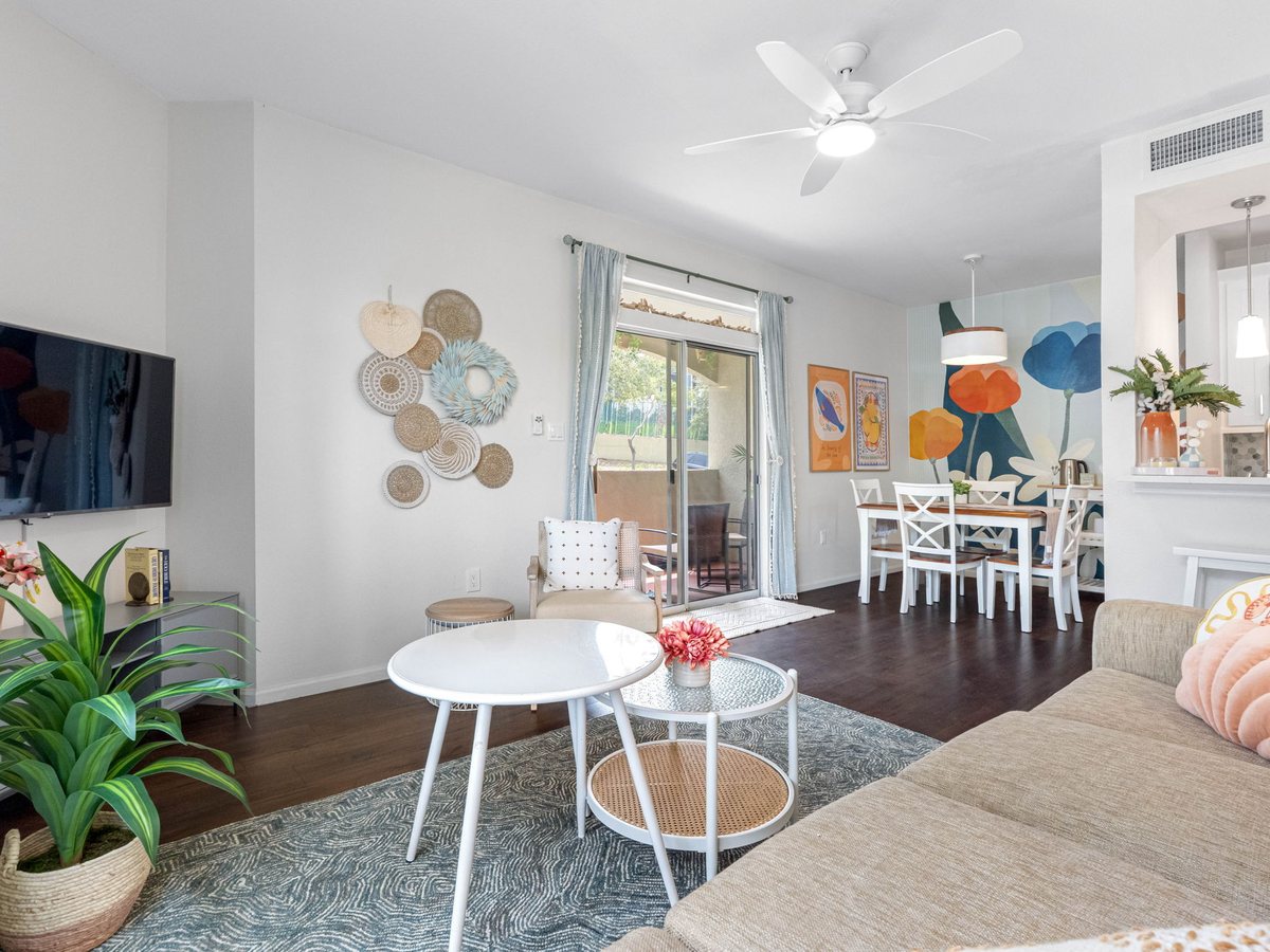 Condo living room with woven wall discs, a floral mural and a coastal palette